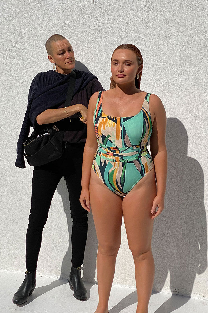 ALULU SS23 swimwear stylist wearing all black standing beside a model in the Alulu Pama onepiece swimsuit